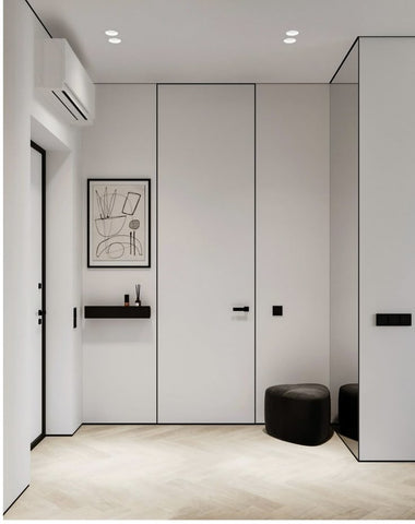 Modern interior with white walls, black fixtures, and a small black stool.